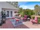 Outdoor wooden deck with seating, a glass table, and charming garden views with potted plants at 1453 Reagan Cir, Conyers, GA 30012