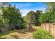 A spacious fenced backyard features mature trees, providing a serene and private outdoor space at 1453 Reagan Cir, Conyers, GA 30012