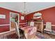 Elegant dining room featuring a chandelier, rich red walls, hardwood floor, and classic furnishings at 1453 Reagan Cir, Conyers, GA 30012