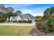 Side view of a one-story home showing the circular driveway, manicured lawn, landscaping, and attached garage at 1453 Reagan Cir, Conyers, GA 30012