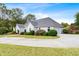 Side view of a one-story home showing the circular driveway, manicured lawn, landscaping, and attached garage at 1453 Reagan Cir, Conyers, GA 30012