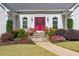 Close up of the front doorway with a vibrant red double door surrounded by lush landscaping at 1453 Reagan Cir, Conyers, GA 30012