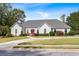 Charming one-story home with a gray roof, red front door, circular driveway, and landscaped front yard at 1453 Reagan Cir, Conyers, GA 30012