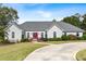 Charming one-story home with a gray roof, red front door, circular driveway, and landscaped front yard at 1453 Reagan Cir, Conyers, GA 30012