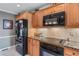 Well-equipped kitchen features black appliances, granite countertops, and light wood cabinetry at 1453 Reagan Cir, Conyers, GA 30012