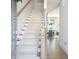 Bright entryway featuring a carpeted staircase with wood railing and an open view to the dining room at 158 Village Green Ave, Woodstock, GA 30189