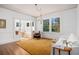 Bright living room with hardwood floors, a large rug, white walls, and large windows overlooking the yard at 3 Park Ne Ln # H, Atlanta, GA 30309
