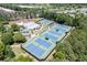 Aerial view of the tennis courts, pool, and clubhouse surrounded by trees, offering a scenic and luxurious community experience at 3835 Greenside Ct, Dacula, GA 30019