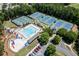 An aerial view showcasing a community pool, playground, and tennis courts surrounded by lush landscaping and neighborhood charm at 3835 Greenside Ct, Dacula, GA 30019