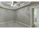 Bedroom with neutral carpeting, tray ceiling, and an ensuite bathroom offers a relaxing retreat at 3835 Greenside Ct, Dacula, GA 30019