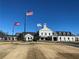 A view of the clubhouse, featuring a traditional architecture with an American flag displayed against a clear blue sky at 3835 Greenside Ct, Dacula, GA 30019