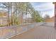Wooden deck with white railings offers a serene view of the surrounding trees and sky at 3835 Greenside Ct, Dacula, GA 30019