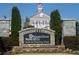 The Hamilton Mill Golf & Country Club entrance, a picturesque stone structure with well-maintained landscaping and flags at 3835 Greenside Ct, Dacula, GA 30019
