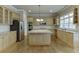 Kitchen featuring an island, stainless appliances, and light wood cabinets at 3835 Greenside Ct, Dacula, GA 30019