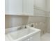 Bright laundry room featuring a large sink, white cabinets and open shelving at 3835 Greenside Ct, Dacula, GA 30019
