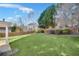 Expansive backyard featuring lush green grass, mature trees, and a wood fence at 5466 Vinings Lake Way, Mableton, GA 30126