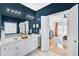 Beautiful bathroom with dual sinks, a large mirror, and an open doorway to the main bedroom at 5466 Vinings Lake Way, Mableton, GA 30126