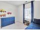 bedroom features blue dresser, carpet, and a sunny window with matching blue curtains at 5466 Vinings Lake Way, Mableton, GA 30126