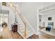 Welcoming foyer featuring hardwood floors, a staircase with carpet runner, and stylish decor at 5466 Vinings Lake Way, Mableton, GA 30126