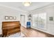Bright living room with wood floors, piano, blue chair, and wainscoting at 5466 Vinings Lake Way, Mableton, GA 30126