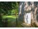 Home exterior featuring a brick wall, fenced yard, and lush green lawn with mature trees at 2116 Strasburg Ct, Dunwoody, GA 30338