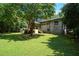 Grassy backyard with a deck, complemented by mature trees and a well-maintained brick house at 2116 Strasburg Ct, Dunwoody, GA 30338
