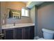 Stylish bathroom with a dark vanity, quartz countertop, and a framed mirror at 2116 Strasburg Ct, Dunwoody, GA 30338
