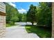 Wide driveway lined with lush greenery leads to a beautiful home at 2116 Strasburg Ct, Dunwoody, GA 30338