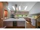 Gourmet kitchen features an island with seating, stainless steel appliances, and plentiful natural light from the skylights at 2116 Strasburg Ct, Dunwoody, GA 30338