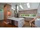 Gourmet kitchen features an island with seating, stainless steel appliances, and plentiful natural light from the skylights at 2116 Strasburg Ct, Dunwoody, GA 30338