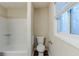 Bathroom featuring a toilet, white tiled walls, and a window providing natural light at 2916 Lloyd Rd, Decatur, GA 30034