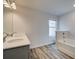 Bathroom featuring double sinks, wood-look tile, and a tub/shower combination with natural light at 324 Shine Dr, Stockbridge, GA 30281