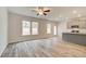 Open-concept living room featuring a ceiling fan, a seamless flow into the kitchen, and ample natural light at 324 Shine Dr, Stockbridge, GA 30281
