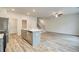 Stylish kitchen with quartz island overlooking open-concept living area and stairs to the upper level at 324 Shine Dr, Stockbridge, GA 30281