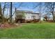 Expansive backyard featuring a lush lawn, mature trees, and a deck attached to the house at 3242 Inns Brook Way, Snellville, GA 30039