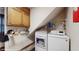 Functional laundry room with modern washer and dryer, cabinets, and shelving at 3242 Inns Brook Way, Snellville, GA 30039