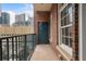 Balcony with city views featuring a brick facade, iron railing, and outdoor access at 77 Peachtree Ne Pl # 402, Atlanta, GA 30309