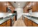 Galley kitchen featuring wood cabinets, stainless steel appliances, and granite countertops at 77 Peachtree Ne Pl # 402, Atlanta, GA 30309