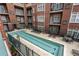 Community pool with a T-shaped design surrounded by brick buildings and lounge seating at 77 Peachtree Ne Pl # 402, Atlanta, GA 30309