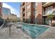 Community swimming pool with lounge chairs surrounded by brick buildings at 77 Peachtree Ne Pl # 402, Atlanta, GA 30309