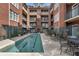 Community swimming pool with lounge chairs surrounded by brick buildings at 77 Peachtree Ne Pl # 402, Atlanta, GA 30309