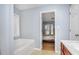 Bathroom featuring a soaking tub, door to the bedroom, and a door to the hall at 1115 Harvest Brook Ne Way, Lawrenceville, GA 30043