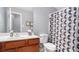 Bathroom features a cherry vanity and shower with a modern geometric patterned shower curtain at 1115 Harvest Brook Ne Way, Lawrenceville, GA 30043