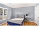 Bedroom with a blue bed, hardwood floors, a large window, and light blue walls at 1115 Harvest Brook Ne Way, Lawrenceville, GA 30043