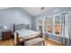 Cozy bedroom with hardwood floors, three windows letting in natural light, and light blue walls at 1115 Harvest Brook Ne Way, Lawrenceville, GA 30043