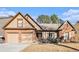 Charming brick home featuring a two-car garage and a neatly maintained front yard with mature landscaping at 1115 Harvest Brook Ne Way, Lawrenceville, GA 30043