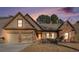 Charming brick home featuring a two-car garage and a neatly maintained front yard with mature landscaping at 1115 Harvest Brook Ne Way, Lawrenceville, GA 30043
