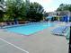 Community pool with blue lounge chairs and umbrellas, surrounded by trees and a covered gazebo at 1115 Harvest Brook Ne Way, Lawrenceville, GA 30043