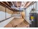 Unfinished basement space with exposed ceiling, cement floor, and hot water tank at 2504 Brentwood Rd, Decatur, GA 30032