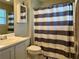 Bathroom with a striped shower curtain, light-colored vanity, and mirrored cabinet at 46 Darbys Crossing Ct, Hiram, GA 30141